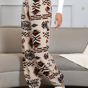 Women's fleece joggers featuring an Aztec pattern in a cozy, ethnic print design, showcasing vibrant colors like orange on a textile material.