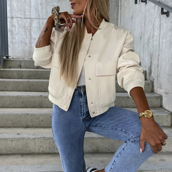 Beige cropped puffer jacket for women, featuring a casual fashion style, shown paired with jeans. The jacket has long sleeves and a high neckline, suitable for a stylish and cozy look.