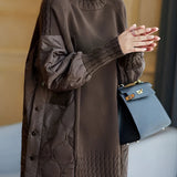 Woman wearing a black turtleneck sweater with puff sleeves, styled for winter fashion; the sweater is paired with brown accessories and the model is showcasing the XL size.