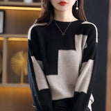 Black and white geometric crewneck sweater with long sleeves and a chic knit pattern, designed for women, displayed flat.