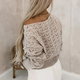 Bohemian off-shoulder crochet sweater in grey, featuring a stylish fall fashion design. The sweater showcases exposed shoulders, long sleeves, and a textured knit pattern, perfect for accentuating a woman's neck and waist. The model has long hair, complementing the chic and relaxed bohemian look.