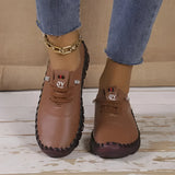 Brown leather loafers with a chain detail being worn by a person. The shoes are styled as casual women's footwear and are shown in a size 43. The setting features elements of white, blue, and purple, highlighting a fashionable look.