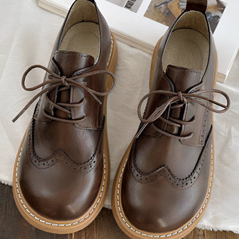 Brown leather wingtip brogues, handcrafted men's formal shoes with intricate brogue detailing, showcasing a classic and elegant design suitable for formal occasions.