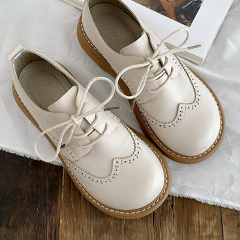 Brown leather wingtip brogues handcrafted for men, featuring intricate perforations and a classic formal design.