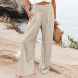 Woman wearing beige bohemian palazzo pants with wide legs, showcasing a flowy summer style. The pants are in a 3XL size and the woman is standing outdoors, accessorized with sunglasses and surrounded by lush greenery.