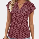 Burgundy geometric keyhole cap sleeve women's summer blouse being worn, highlighting the cutout neckline and cap sleeves.