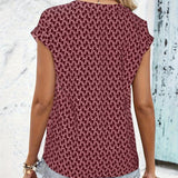 
A burgundy geometric patterned keyhole cap sleeve women's summer blouse displayed on a mannequin, highlighting its unique neckline and stylish design.