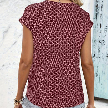 
A burgundy geometric patterned keyhole cap sleeve women's summer blouse displayed on a mannequin, highlighting its unique neckline and stylish design.