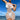 Handmade white crochet one-piece swimsuit modeled outdoors near water with blue sky and clouds.