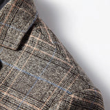 A stylish men's herringbone wool tweed blazer in grey, featuring a tailored fit perfect for winter office wear. The blazer showcases a classic plaid pattern with a structured collar and long sleeves, highlighting the fine woolen textile craftsmanship.