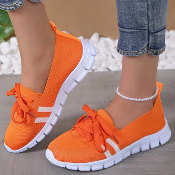 Lightweight breathable grey women's sneakers with orange accents, size 42, designed for comfortable walking, displayed on a person's foot.