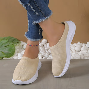 Lightweight women's breathable mesh slip-on sneakers in beige, shown on a model's feet, highlighting their comfortable and stylish summer design.