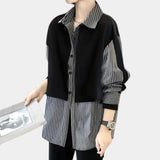 Asymmetrical black and white striped women's jacket featuring a tailored fit with a unique design on the shoulders, long sleeves, and a structured collar.