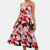 A model wearing a red XL spaghetti strap maxi dress with a geometric pattern, suitable for summer. The dress features a fitted waist, sleeveless design, and flowing skirt, showcasing a stylish and casual look.