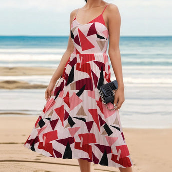 A woman wearing a pink geometric spaghetti strap maxi dress suitable for summer, featuring a fitted waist and flowing skirt, with a serene outdoor backdrop.