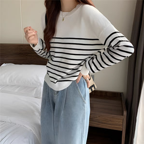 Striped crewneck sweater in black and white with a loose fit design, featuring long sleeves and a comfortable pullover style for women.