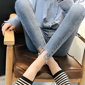 Women's casual denim striped flats with a chained ankle design, paired with jeans.