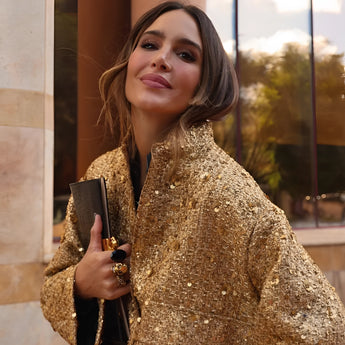 Textured gold metallic bomber jacket in XL size worn by a smiling woman with long hair. The jacket features a fashionable design with visible sleeves, suitable for chic women's outerwear.