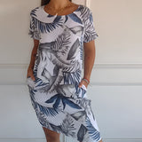 Tropical print sleeveless shift dress in white for women, featuring a loose fit with a vibrant pattern, designed for summer beachwear. The dress is shown on a smiling model, highlighting its neckline and comfortable fit, suitable for a 3XL size.