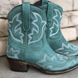 Turquoise suede cowboy boots for women featuring intricate western embroidery, shown in a green color variant, size 43.