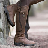 Waterproof durable leather equestrian riding boots for women in dark brown, shown in a knee-high style, highlighting the elegant fashion design with a focus on the leather material and compatibility with denim clothing.