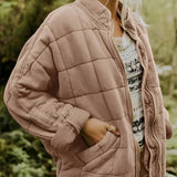 
A women's lightweight insulated forest green quilted jacket in khaki color, displayed in size 2XL. The jacket features a quilted pattern with a focus on outerwear elements such as a high neckline, long sleeves, and a fitted waist. It is made from natural materials and designed for comfort and style.