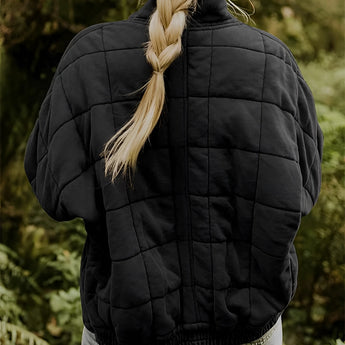 Women's forest green quilted jacket with a lightweight design, featuring long sleeves, worn by a person with long hair standing in a natural setting.