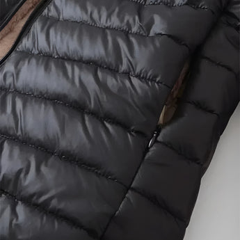 A women's lightweight insulated water-resistant puffer jacket in a neutral grey color hanging on a coat rack.