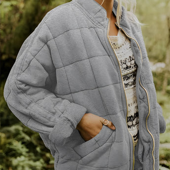 
A gray women's lightweight insulated quilted jacket in size 2XL, featuring a high collar, long sleeves, and a fitted waist.