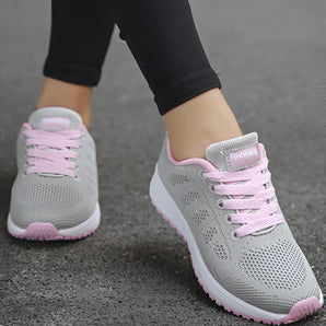 Women's lightweight sneakers in a pink color, designed for running and featuring a breathable textile upper, shown against a neutral background.