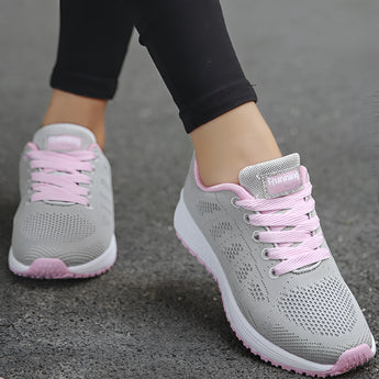 Women's lightweight sneakers in a pink color, designed for running and featuring a breathable textile upper, shown against a neutral background.