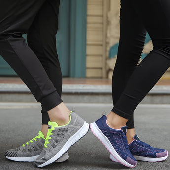 Women's lightweight pink running sneakers with breathable textile material, shown worn on a person's feet paired with grey sportswear leggings.